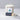 Lucette+Mo Escape Candle – coastal citrus-scented luxury candle with ocean wave artwork shown with matches