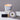 Lucette+Mo Daydream 6oz Travel Candle – soft floral candle tin with marigold, vanilla, and cedar shown with matches.
