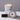 Lucette+Mo Daydream 6oz Travel Candle – soft floral candle tin with marigold, vanilla, and cedar shown with matches.